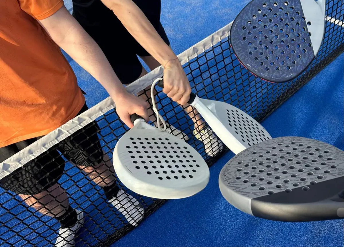 Padel players tapping rackets over the net after a point