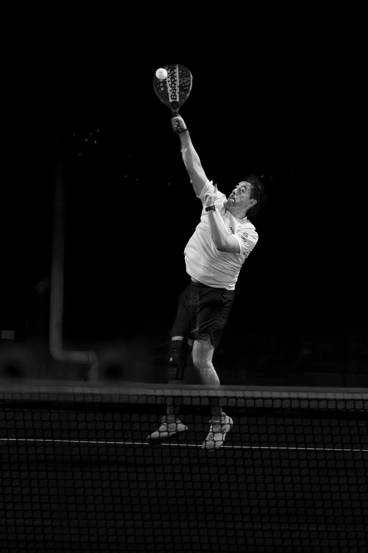 Two padel players in a fast exchange at the net