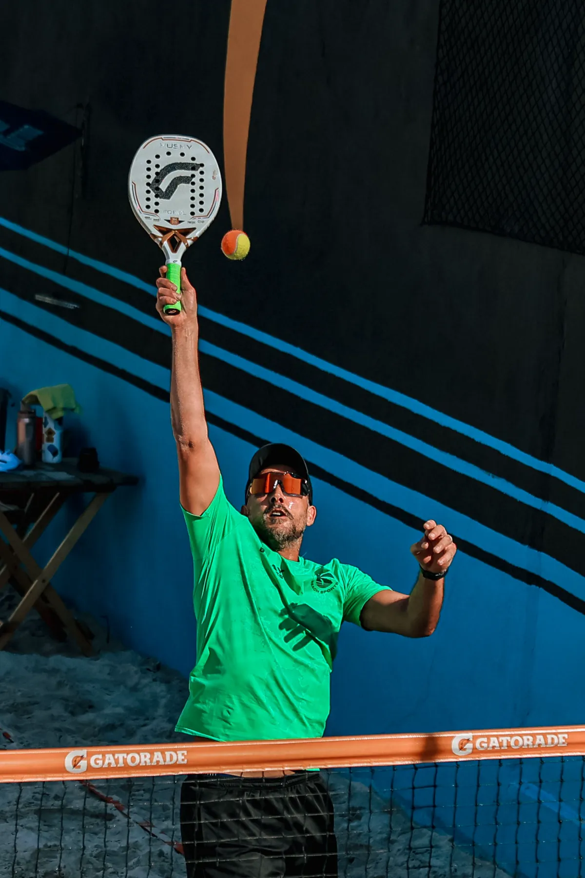 A padel player leaping to smash the ball on an outdoor court