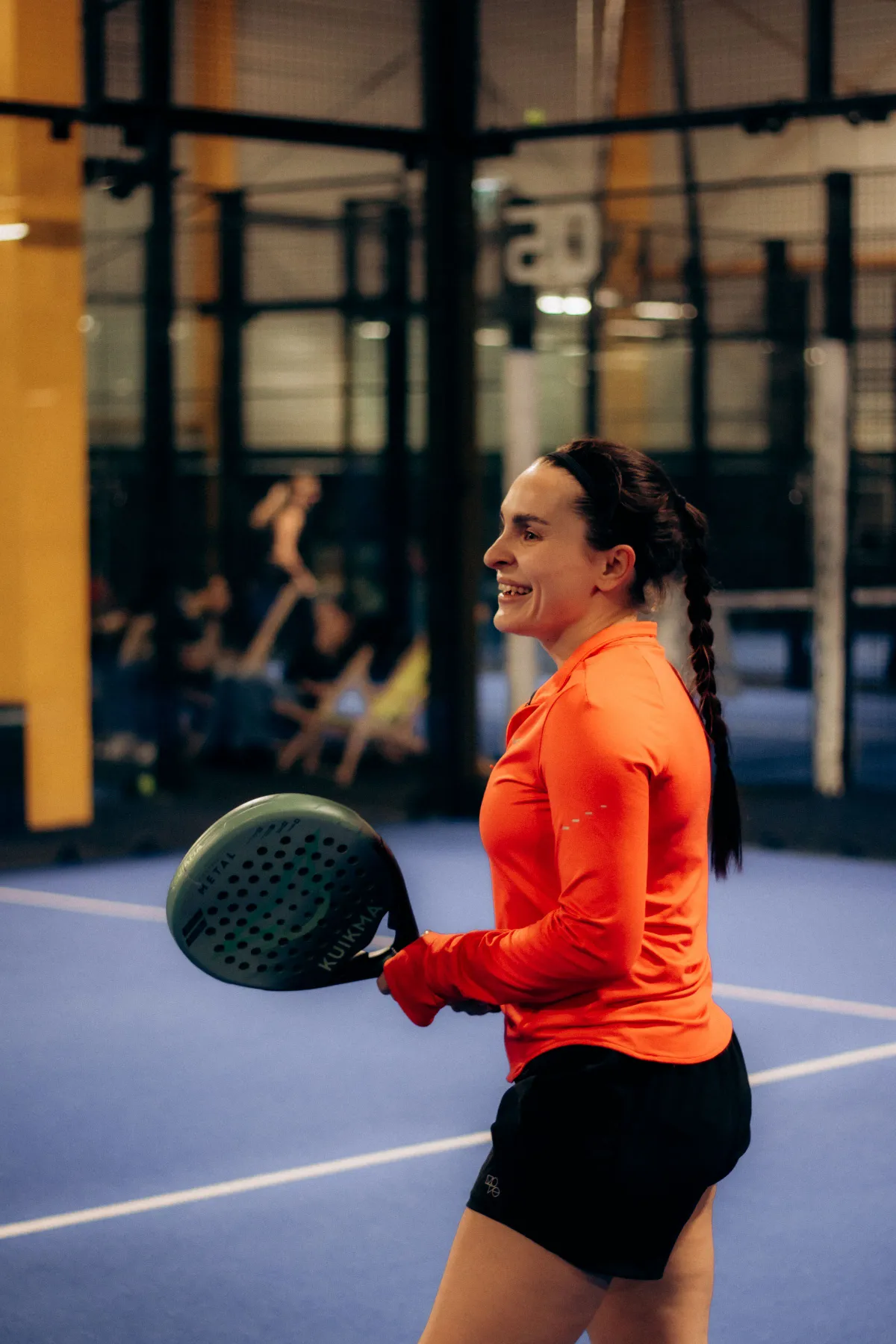 A padel player on an indoor court